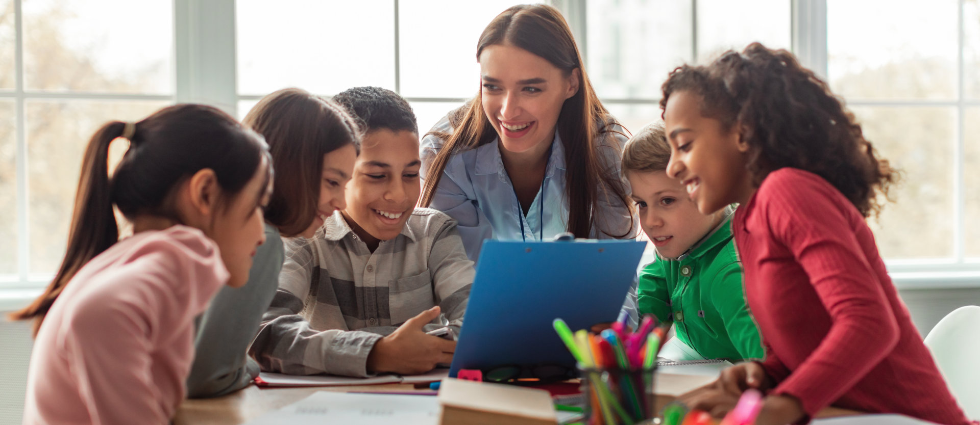 diverse school children and teacher woman having class in classroom