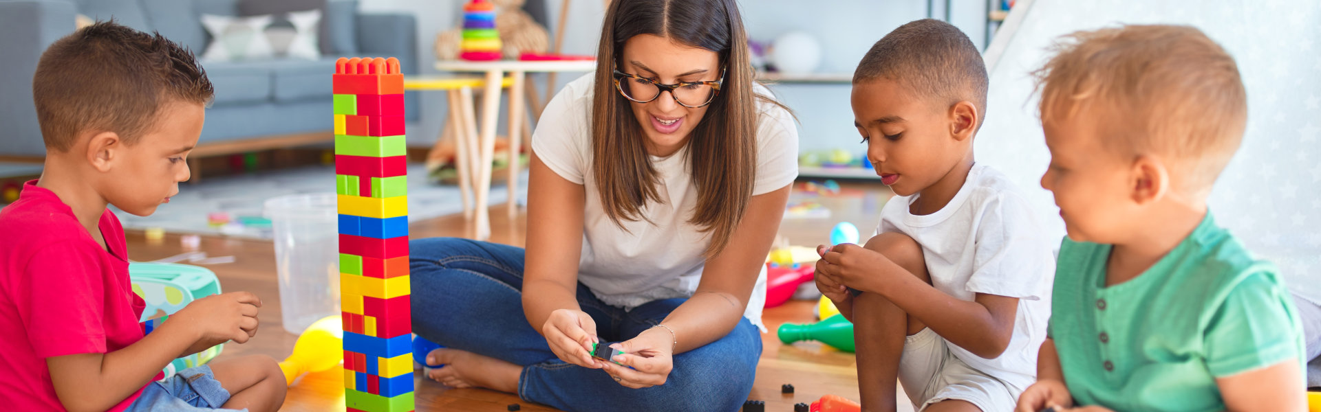 three little boys and a woman playing with legos